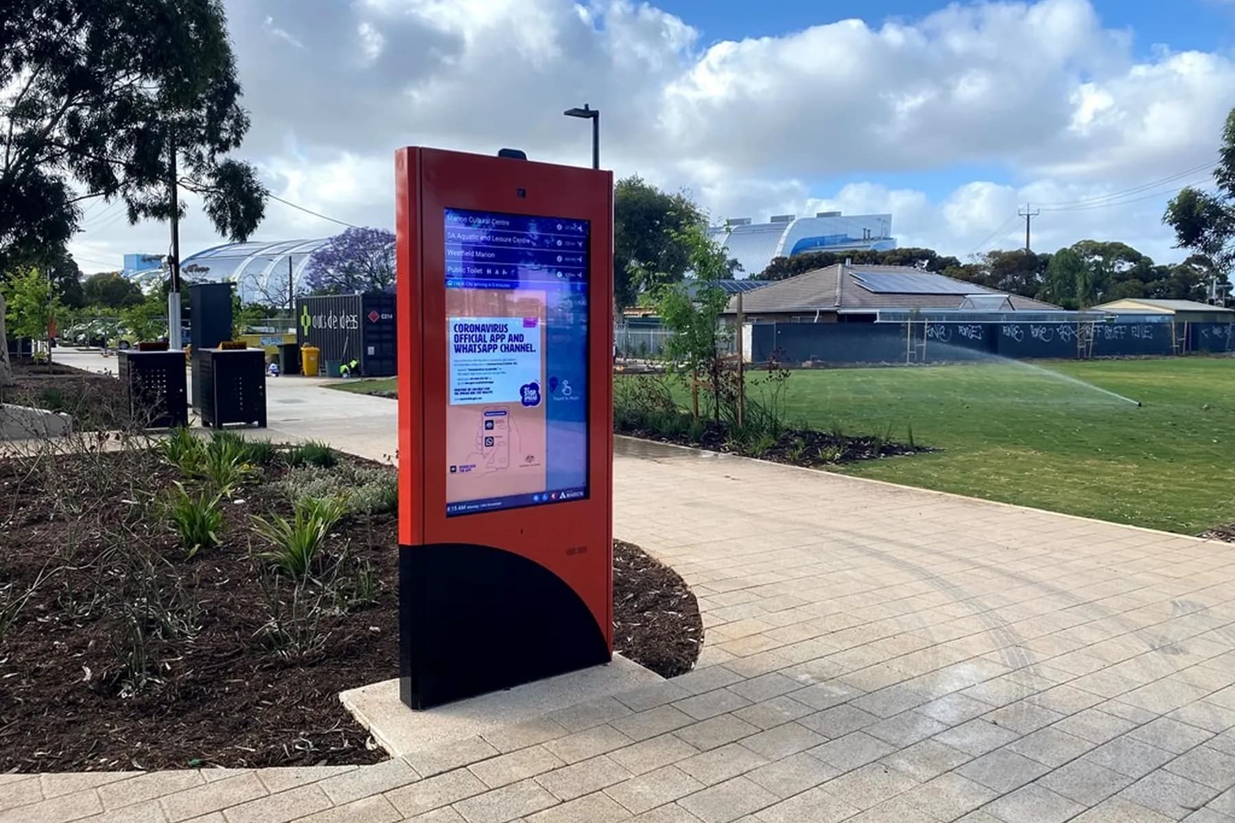 Freestanding outdoor digital wayfinding totem beside a public path