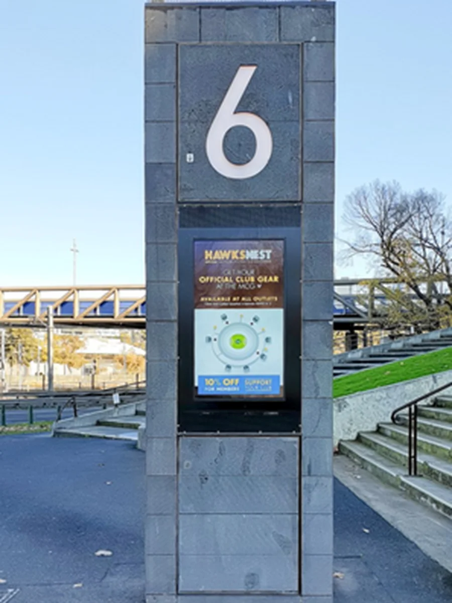 Commercial display integrated into a masonry entry pylon at a sports and events venue