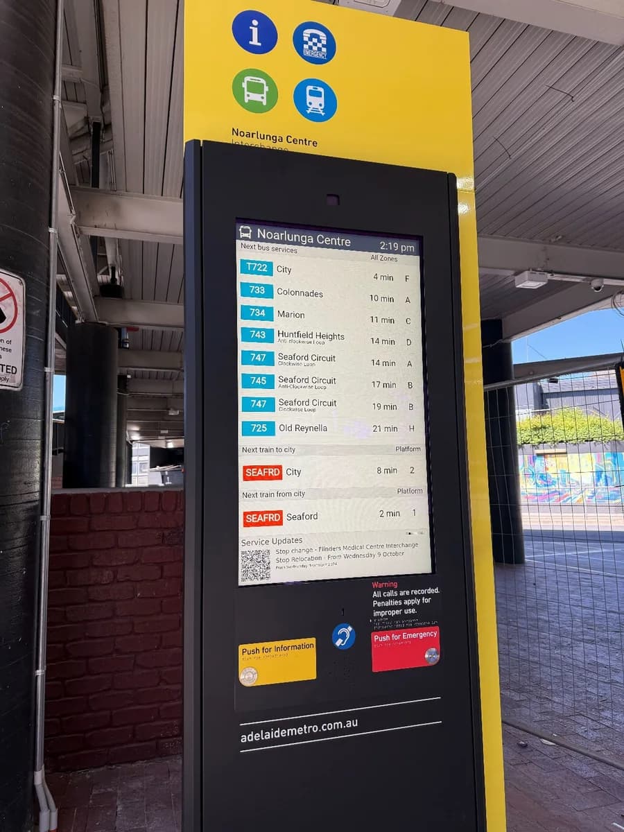 Touchscreen information kiosk showing live service times at a transport interchange