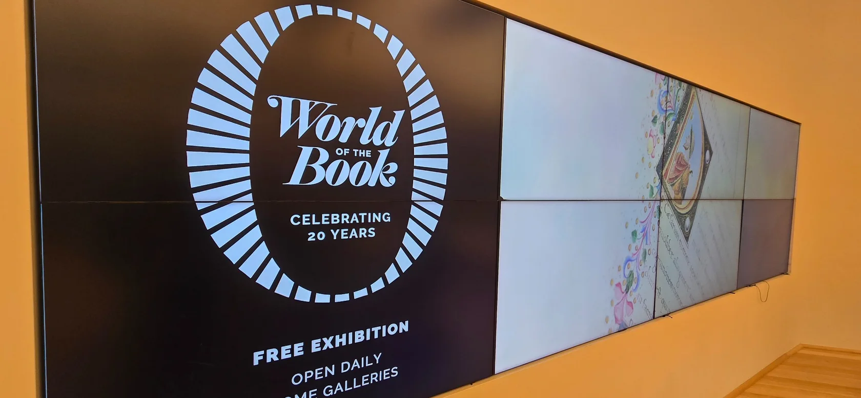 Tiled LCD video wall running exhibition content across a public interior wall