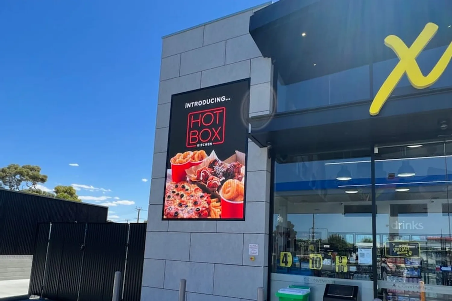 Building-mounted high-brightness outdoor display at a fuel and convenience site
